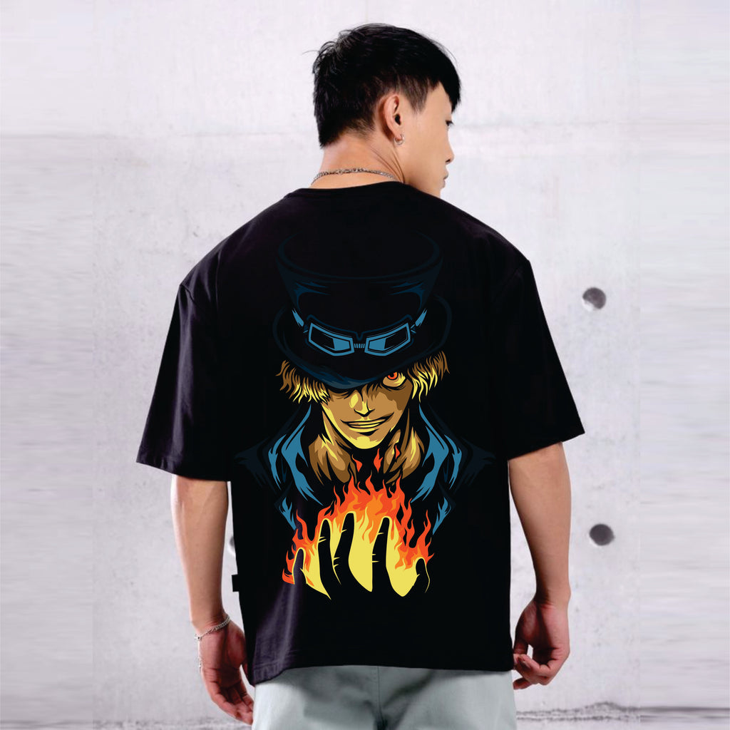 Person wearing a black t-shirt with a colorful graphic SOBO design on the back against a white brick wall.