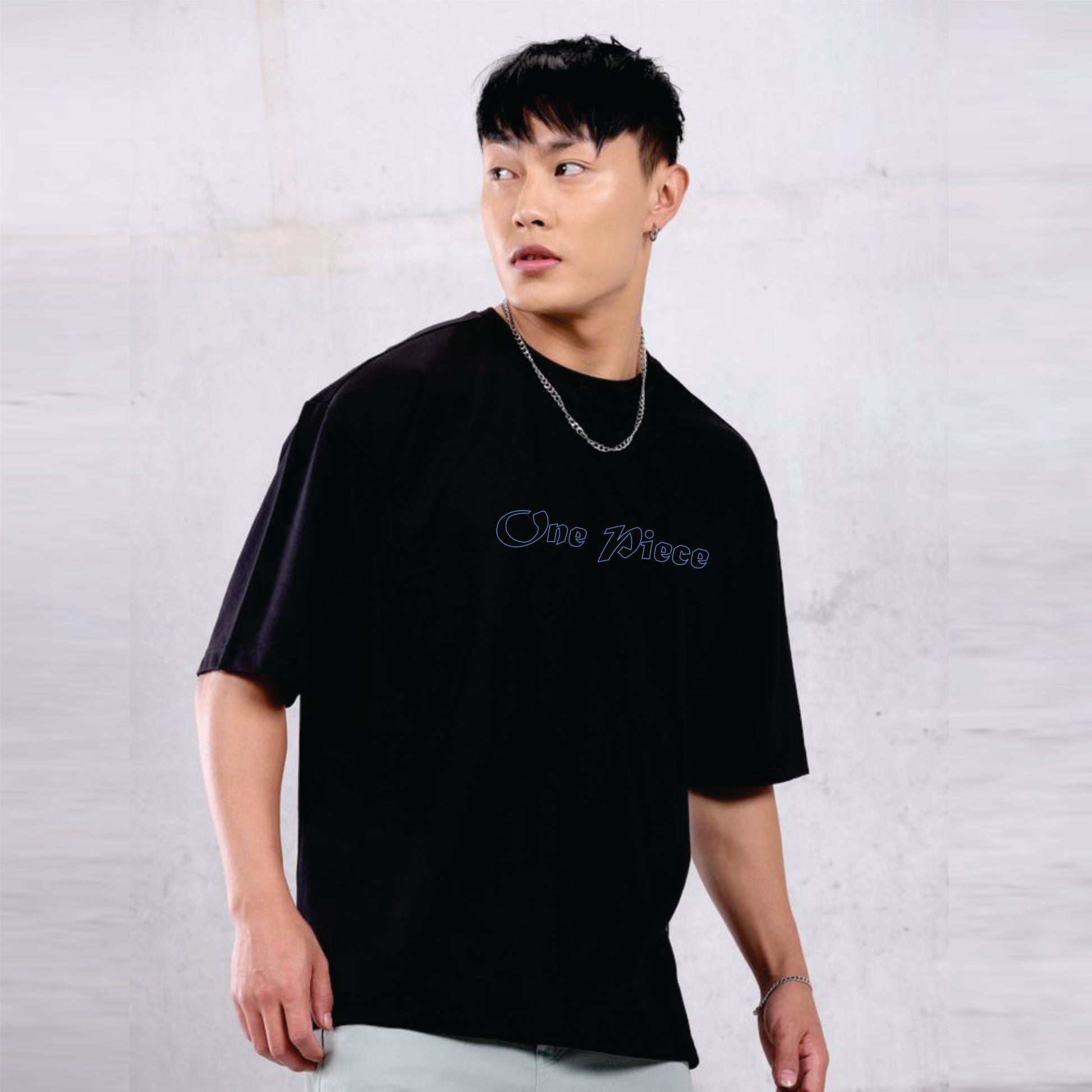Person wearing a black t-shirt with 'One Piece' logo against a plain background