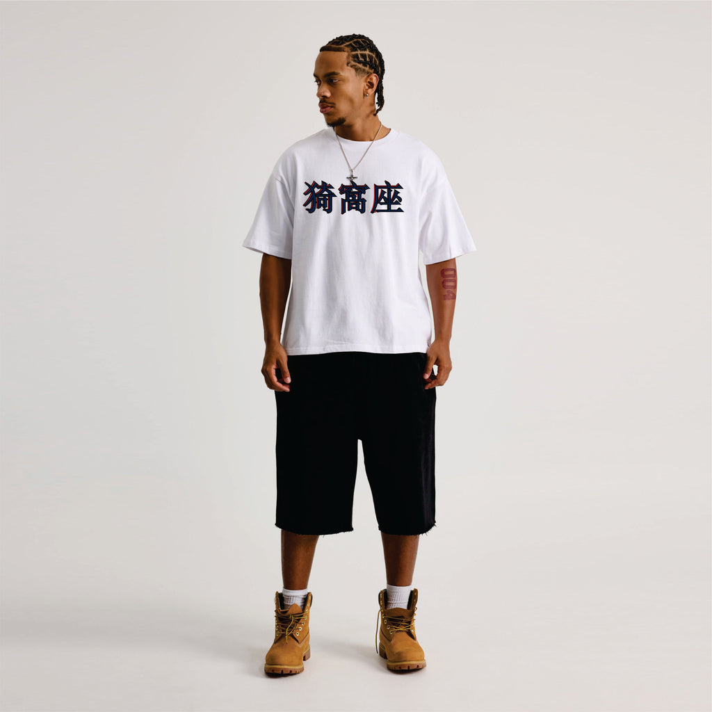 Person wearing a white t-shirt with black text, black shorts, and brown boots on a light gray background