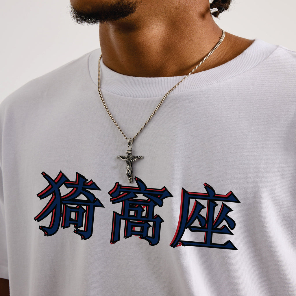 Person wearing a white t-shirt with blue and red characters and a necklace.