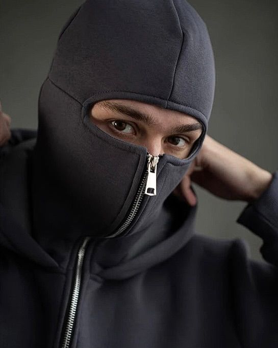 Person wearing a black balaclava with a zipper, looking directly at the camera.