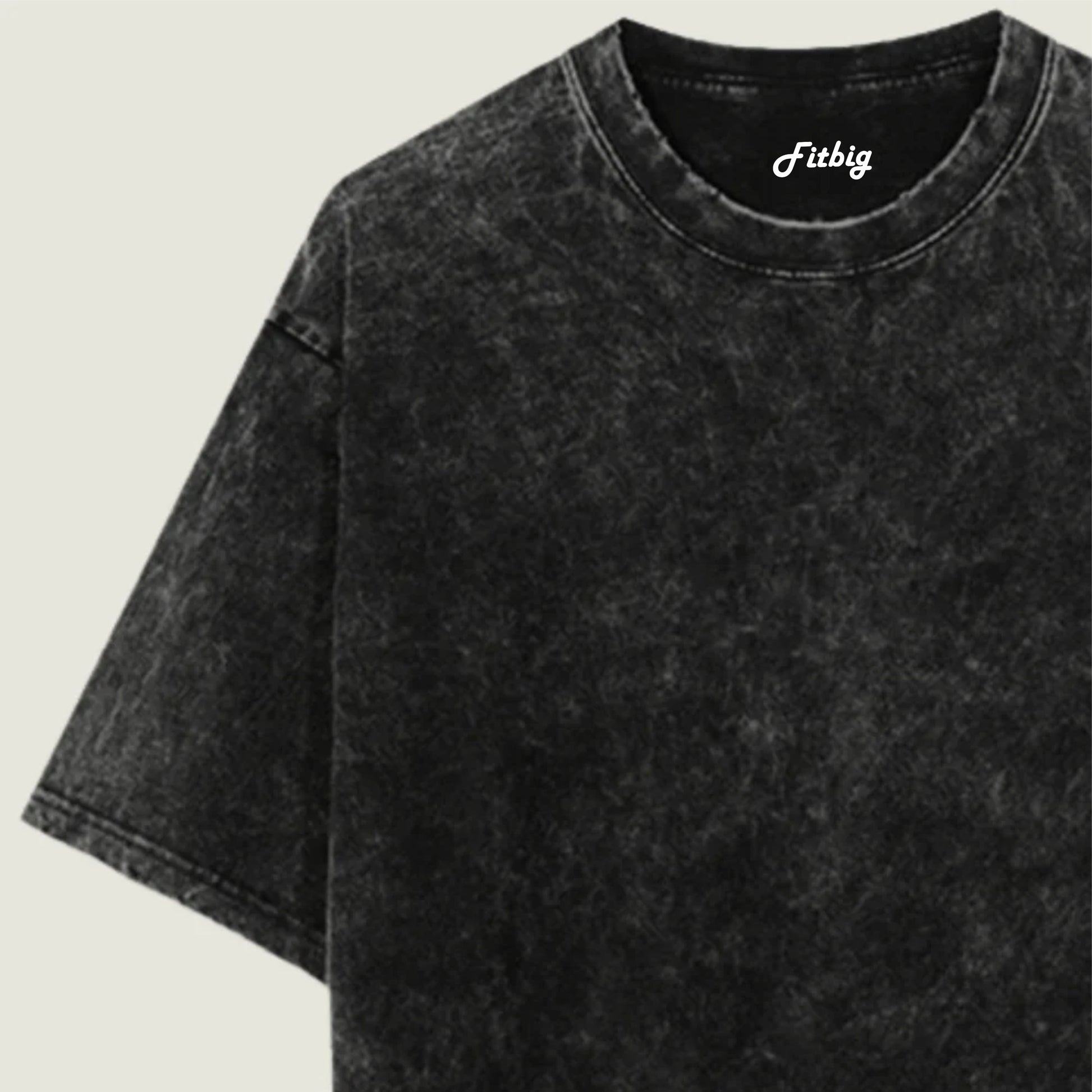 Black acid-wash t-shirt with 'Fitbig' logo on a beige background