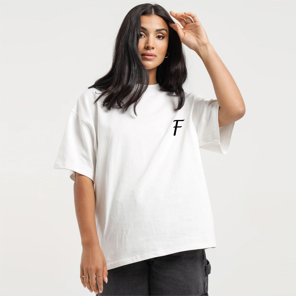 Woman wearing a white t-shirt with a black logo on a plain background