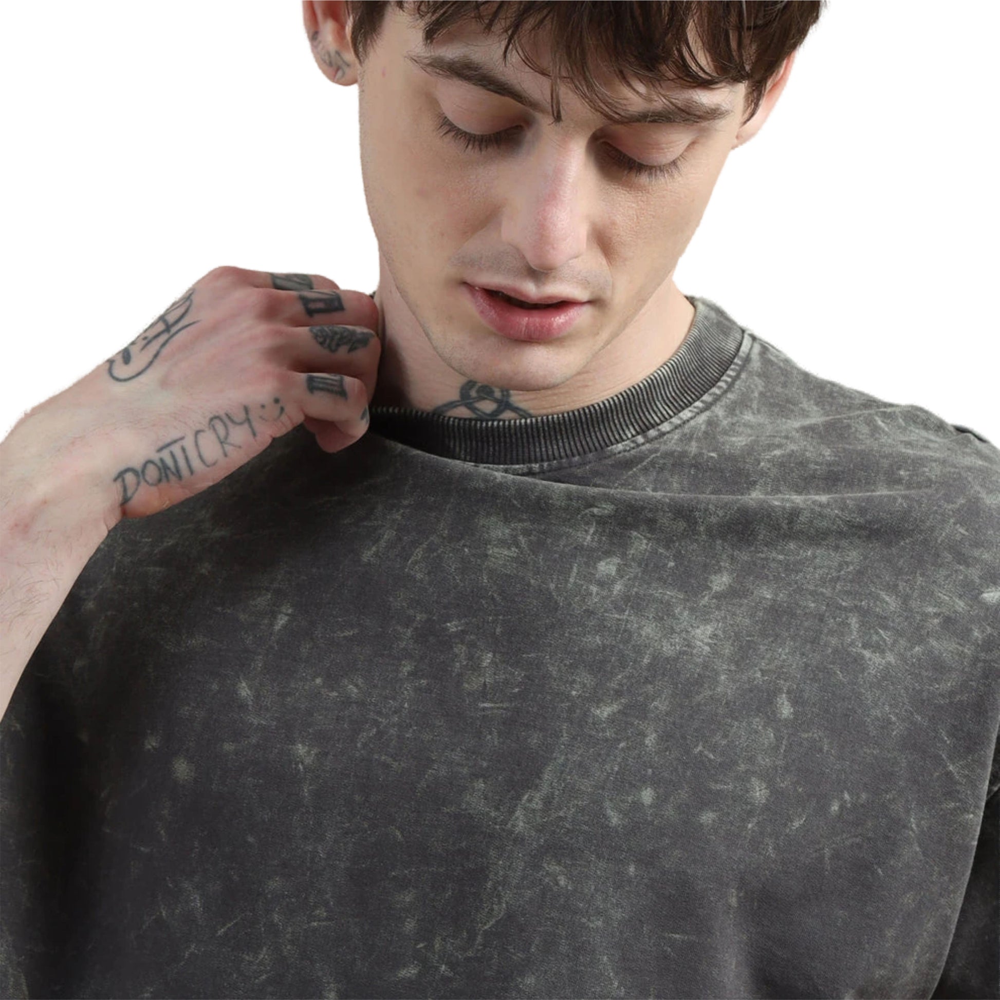Man wearing a gray distressed t shirt with tattoos on his arm.