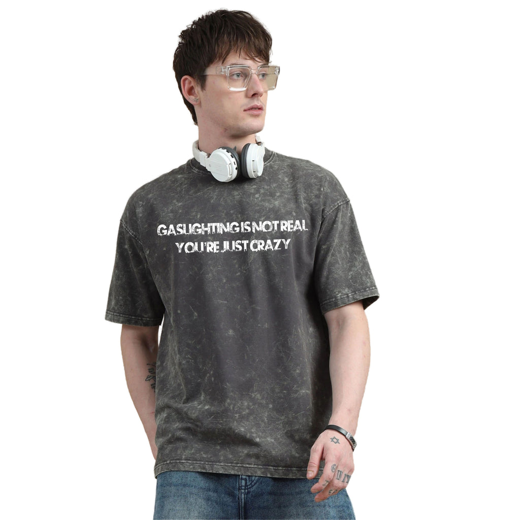 Person wearing a gray t-shirt with text and headphones on a white background