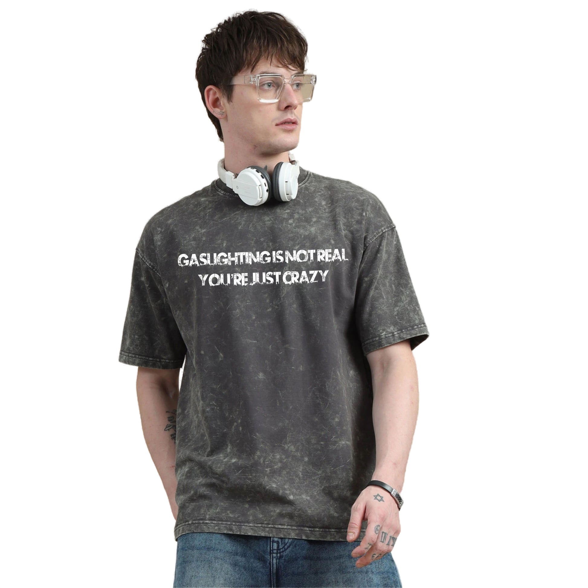Person wearing a gray t-shirt with text and headphones on a white background