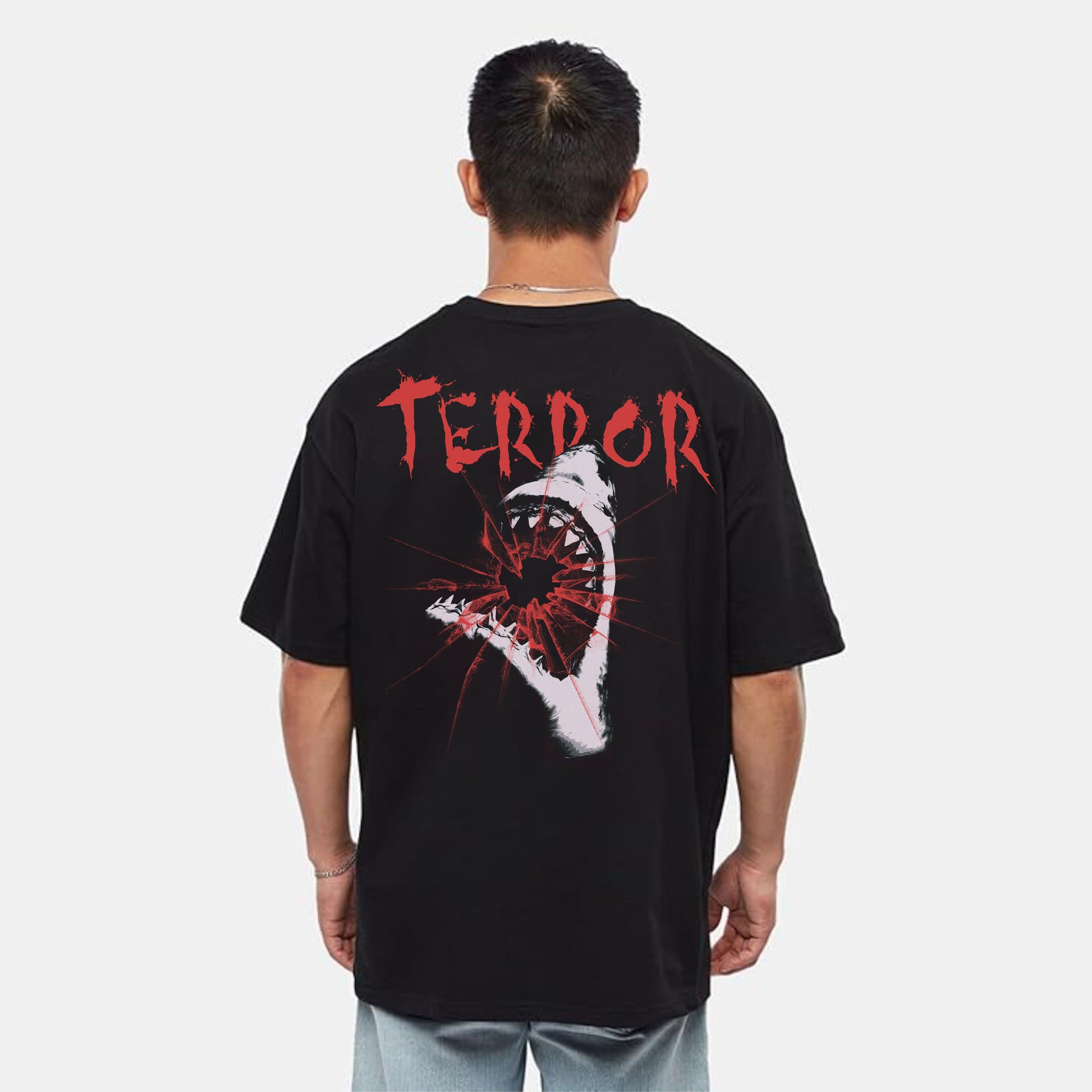 Person wearing a black t-shirt with 'TERROR' printed on the back against a white background