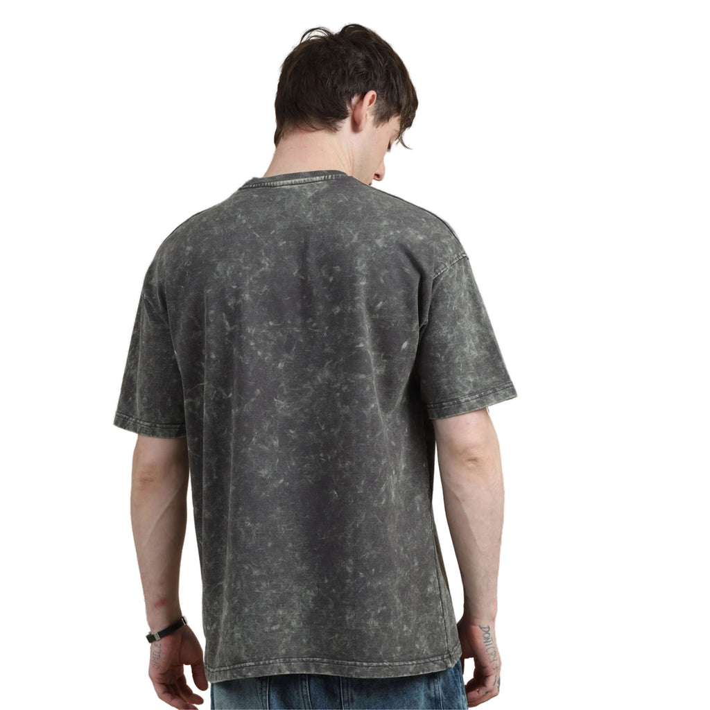 Person wearing a black acid-wash t-shirt on a white background