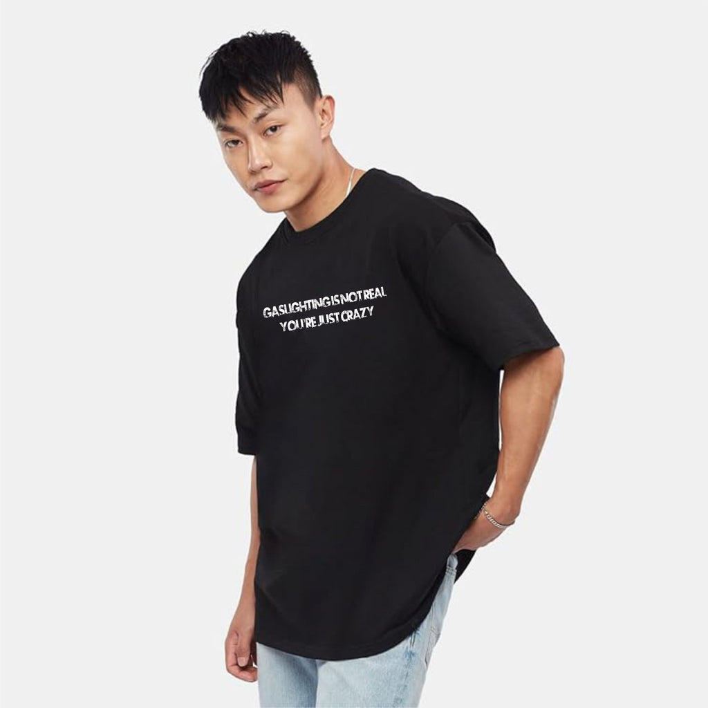 Person wearing a black t-shirt with white text on a plain background